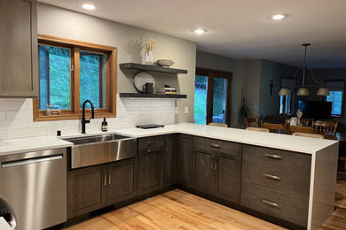 Example of a mid-sized trendy u-shaped eat-in kitchen design in Other with shaker cabinets, quartz countertops and white backsplash