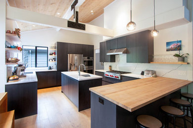 Kitchen - contemporary medium tone wood floor and brown floor kitchen idea in Other with flat-panel cabinets, quartz countertops, white backsplash, quartz backsplash, stainless steel appliances, an island and white countertops