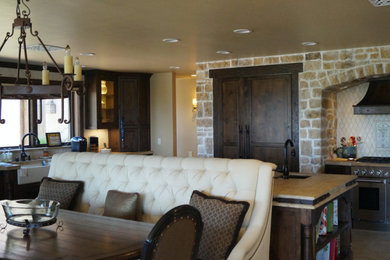 Large mountain style l-shaped eat-in kitchen photo in Los Angeles with a farmhouse sink, recessed-panel cabinets, dark wood cabinets, white backsplash, ceramic backsplash, stainless steel appliances and an island