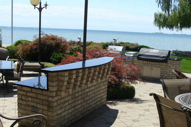 Inspiration for a large backyard concrete paver patio kitchen remodel in Detroit with no cover