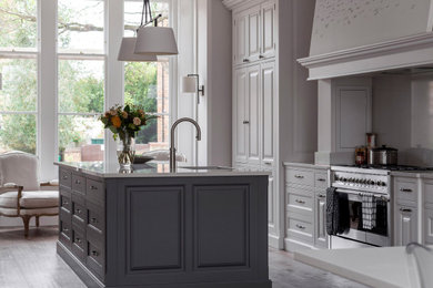This is an example of a classic kitchen in Oxfordshire with quartz worktops, stainless steel appliances, medium hardwood flooring and beige worktops.