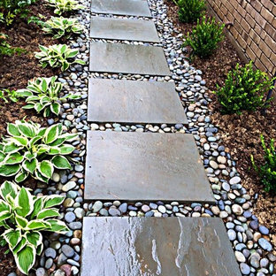 Cette photo montre un jardin latéral tendance de taille moyenne avec une entrée ou une allée de jardin, une exposition partiellement ombragée et des pavés en pierre naturelle.