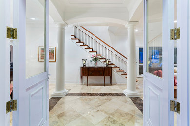 Photo of a large modern foyer in Miami with white walls, porcelain floors, a double front door, a white front door and multi-coloured floor.
