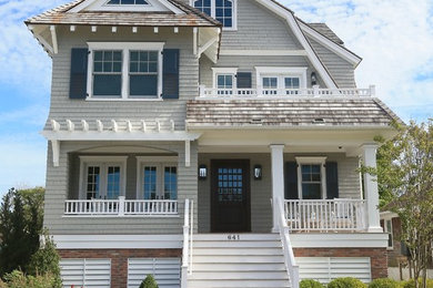 Beach style beige house exterior photo in New York with a gambrel roof and a shingle roof