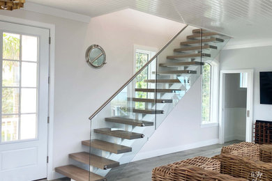 Modelo de escalera minimalista de tamaño medio sin contrahuella con escalones de madera y barandilla de vidrio