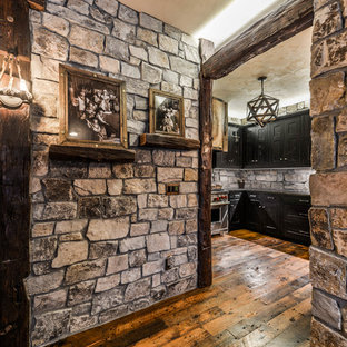 This is an example of a large rustic walk-out basement in Minneapolis with brown walls, dark hardwood flooring and orange floors.