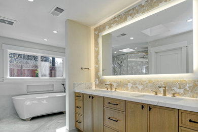 Bathroom - huge modern master beige tile and porcelain tile porcelain tile, brown floor and double-sink bathroom idea in San Francisco with recessed-panel cabinets, light wood cabinets, a one-piece toilet, beige walls, an undermount sink, quartz countertops, a hinged shower door, white countertops and a built-in vanity