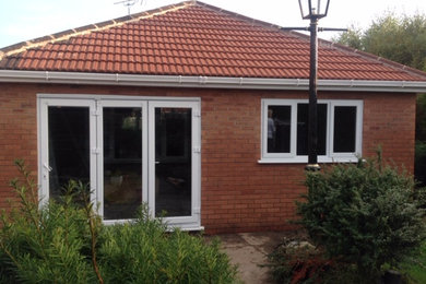 Medium sized classic bungalow brick detached house in West Midlands with a hip roof and a tiled roof.