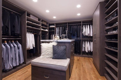Inspiration for a mid-sized transitional men's light wood floor and brown floor walk-in closet remodel in DC Metro with flat-panel cabinets and medium tone wood cabinets