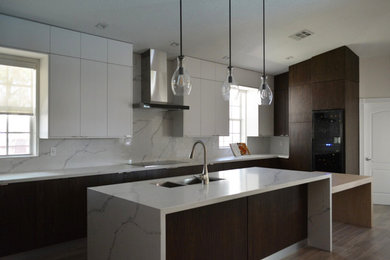 Example of a large transitional u-shaped medium tone wood floor and brown floor open concept kitchen design in Miami with a double-bowl sink, flat-panel cabinets, dark wood cabinets, quartzite countertops, white backsplash, marble backsplash, paneled appliances, an island and white countertops