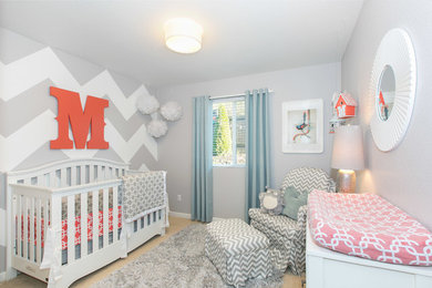 Example of a mid-sized transitional gender-neutral carpeted nursery design in Seattle with gray walls