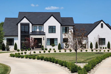 Inspiration for a contemporary two-story brick house exterior remodel in St Louis with a black roof