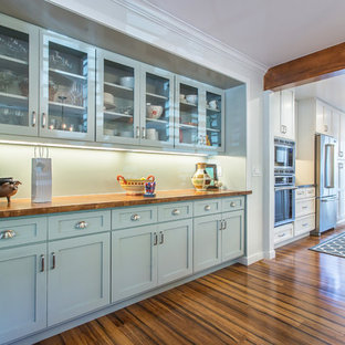 Klassisk inredning av ett stort kök med matplats, med bambugolv och vita väggar