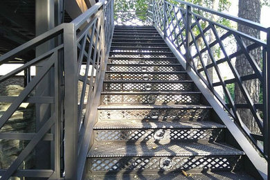 Imagen de escalera grande con escalones de metal, contrahuellas de metal y barandilla de metal