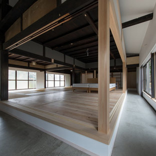 Idee per una grande camera matrimoniale etnica con pareti bianche, parquet chiaro, stufa a legna, cornice del camino in cemento e pavimento beige