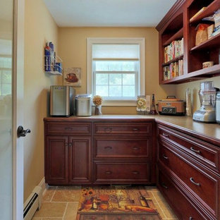 Idée de décoration pour une arrière-cuisine méditerranéenne en L de taille moyenne avec un placard avec porte à panneau encastré, des portes de placard en bois sombre, un plan de travail en stratifié, un électroménager en acier inoxydable et un sol en travertin.