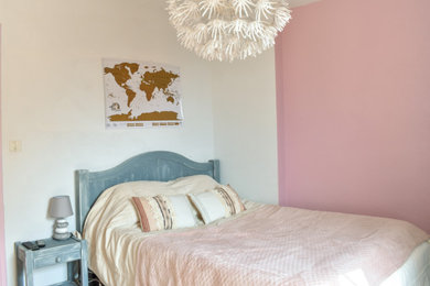 Idée de décoration pour une chambre parentale champêtre de taille moyenne avec un mur rose, aucune cheminée et un sol marron.