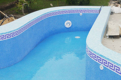 Пример оригинального дизайна: наземный бассейн среднего размера, произвольной формы на боковом дворе в стиле неоклассика (современная классика) с домиком у бассейна и покрытием из плитки