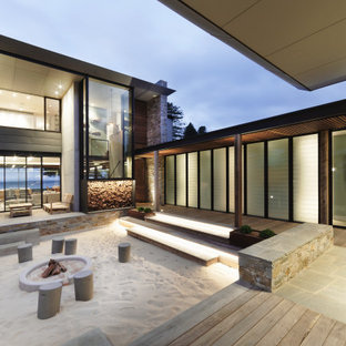 Photo of a mid-sized contemporary side yard garden in Central Coast with a fire feature.