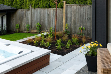 Photo of a contemporary backyard concrete paver landscaping in Vancouver.