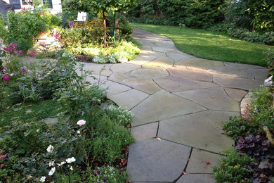 Photo of a mid-sized country backyard patio in Minneapolis with natural stone pavers.