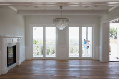 Large beach style formal and open concept medium tone wood floor living room photo in Los Angeles with white walls, a standard fireplace and a stone fireplace