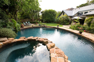 Example of a mountain style backyard stone and custom-shaped pool design in Austin