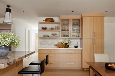 Example of a transitional l-shaped kitchen design in San Francisco with flat-panel cabinets, medium tone wood cabinets, stainless steel appliances and an island