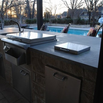 Outdoor Kitchen with Clean Concrete Countertops with Charcoal and Gas Grills