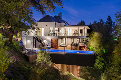 Example of a trendy white two-story house exterior design in Los Angeles with a hip roof