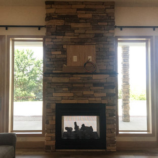 Two-Sided Fireplace with Stone Surround and TV mounted above