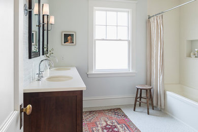 This is an example of a mid-sized traditional master bathroom in Minneapolis with shaker cabinets, dark wood cabinets, an alcove tub, a shower/bathtub combo, a two-piece toilet, blue tile, ceramic tile, blue walls, porcelain floors, an undermount sink, solid surface benchtops, white floor, a shower curtain and white benchtops.