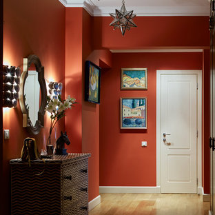 Foto på en vintage hall, med röda väggar och mellanmörkt trägolv