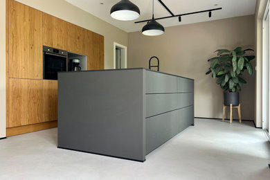 Idées déco pour une cuisine moderne de taille moyenne avec sol en béton ciré et un sol gris.