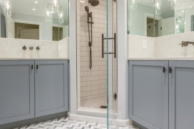Mid-sized elegant kids' white tile and ceramic tile marble floor, multicolored floor and single-sink alcove shower photo in Cincinnati with recessed-panel cabinets, gray cabinets, a one-piece toilet, gray walls, an undermount sink, quartzite countertops, a hinged shower door, white countertops and a built-in vanity