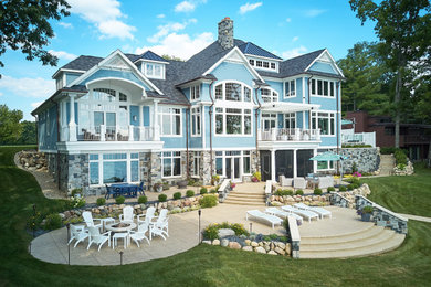 Inspiration for a huge coastal backyard deck remodel in Grand Rapids with a fire pit