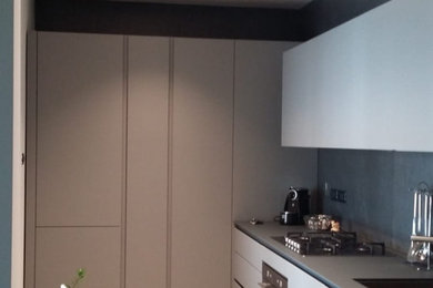 Ispirazione per una cucina a L minimalista chiusa e di medie dimensioni con lavello sottopiano, ante lisce, ante grigie, top in laminato, paraspruzzi grigio, paraspruzzi con piastrelle in ceramica, elettrodomestici in acciaio inossidabile, pavimento in gres porcellanato, pavimento beige e top grigio