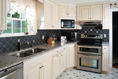 Inspiration for a timeless l-shaped linoleum floor kitchen pantry remodel in New York with a double-bowl sink, louvered cabinets, white cabinets, granite countertops, black backsplash, ceramic backsplash and stainless steel appliances