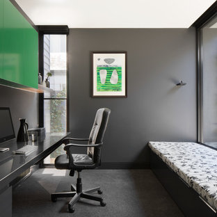 Medium sized modern study in Melbourne with black walls, carpet and a built-in desk.