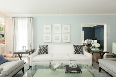 Inspiration for a transitional living room in New York with blue walls, medium hardwood floors and brown floor.