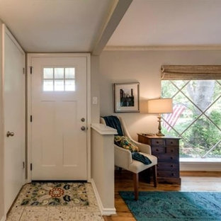 Bild på en eklektisk entré, med grå väggar, terrazzogolv, en enkeldörr och en vit dörr