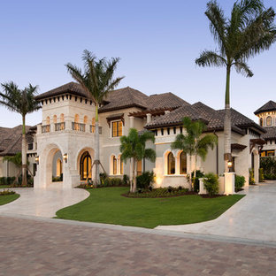 Beigefarbenes Mediterranes Einfamilienhaus mit Walmdach und Schindeldach in Sonstige