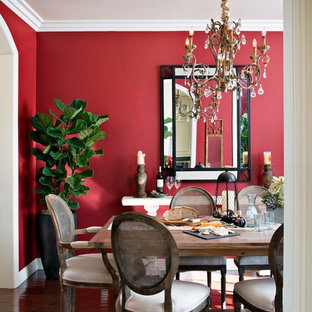 Inspiration pour une salle à manger traditionnelle fermée et de taille moyenne avec un mur rouge et un sol en bois foncé.