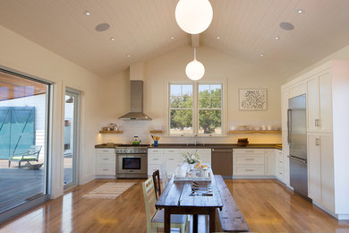 Mid-sized cottage u-shaped medium tone wood floor eat-in kitchen photo in San Francisco with an undermount sink, shaker cabinets, white cabinets, quartz countertops, white backsplash, subway tile backsplash, stainless steel appliances and no island