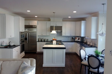Inspiration for a large transitional u-shaped dark wood floor and brown floor open concept kitchen remodel in DC Metro with recessed-panel cabinets, white cabinets, quartzite countertops, gray backsplash, stone tile backsplash, stainless steel appliances and an island