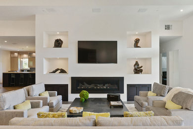 Inspiration for an expansive transitional open concept family room in San Francisco with a home bar, white walls, light hardwood floors, a ribbon fireplace, a metal fireplace surround, a wall-mounted tv and beige floor.