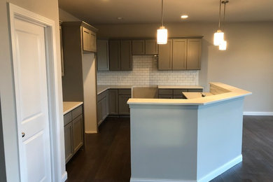 Inspiration for a timeless medium tone wood floor kitchen remodel in Detroit with shaker cabinets, quartzite countertops and subway tile backsplash