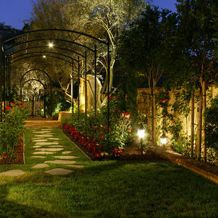 Cette photo montre un jardin à la française latéral méditerranéen au printemps et de taille moyenne avec des pavés en pierre naturelle, une entrée ou une allée de jardin et une exposition partiellement ombragée.