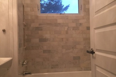 Ispirazione per una stanza da bagno shabby-chic style con piastrelle in pietra, pavimento in marmo e lavabo a colonna