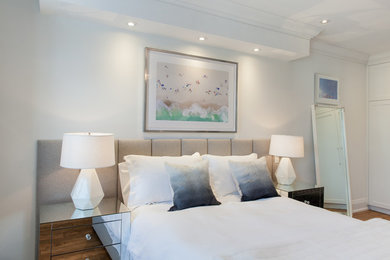 Inspiration for a transitional medium tone wood floor and brown floor bedroom remodel in Toronto with white walls
